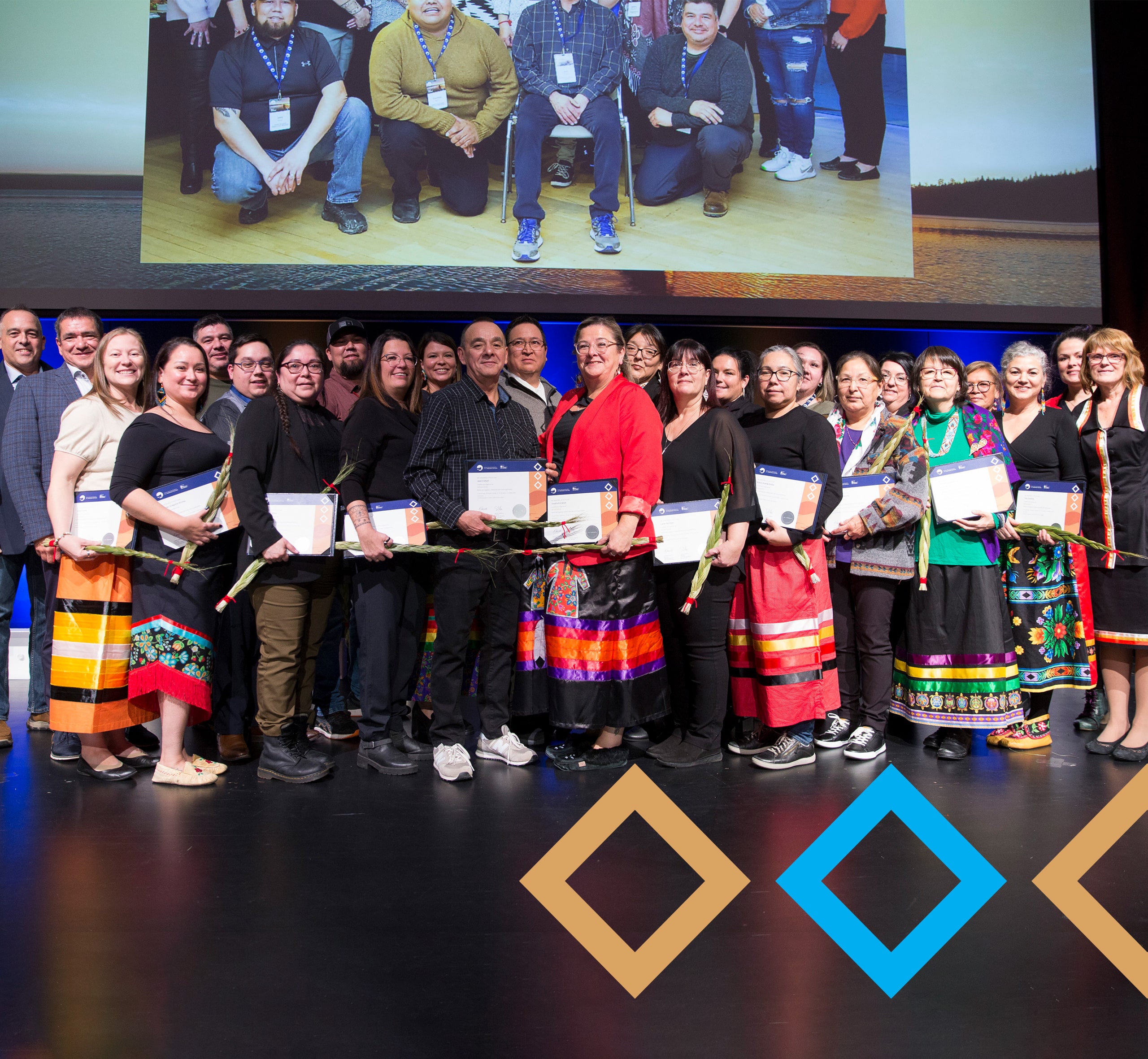Twenty-two (22) participants stand proudly on the stage at HEC downtown Montreal as they receive their certifications for successfully completing the 'Solidify and Sharpen Your Entrepreneurial Skills' program. Vingt-deux (22) participant.e.s se tiennent fièrement sur la scène de HEC au centre-ville de Montréal alors qu'ils reçoivent leurs certifications pour avoir réussi avec succès le programme 'Solidifier et Aiguiser vos Compétences Entrepreneuriales'.